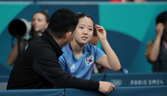 2일(현지시간) 프랑스 파리 사우스 파리 아레나에서 열린 2024 파리올림픽 탁구 여자 단식 4강전에서 한국 신유빈이 중국 천멍에게 패배한 뒤 아쉬워하며 오광헌 감독과 대화하고 있다. [파리=연합뉴스]